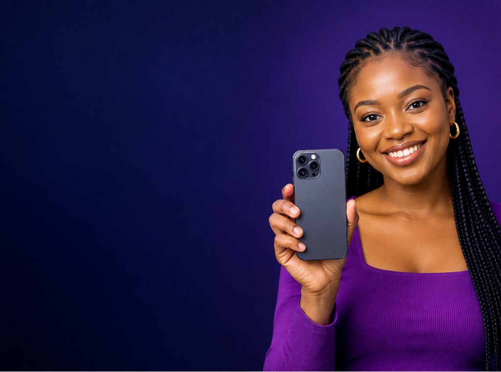 A smiling woman holding up a modern smartphone against a deep purple background